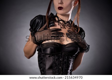 Close-up shot of attractive young woman in Victorian style corset and jewelry, studio shot