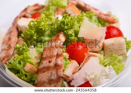Close-up shot of delicious Caesar salad with grilled chicken meat
