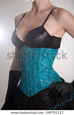 Close-up shot of attractive young woman in blue corset and black skirt