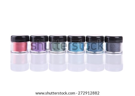 Set of mineral eye shadows in clear plastic jars, isolated on white background with natural reflection