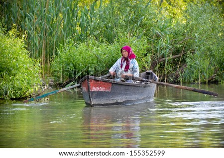VILKOVO, UKRAINE - May 19: Danube delta. Undefined old woman floating in a boat. Vilkovo-city on the water at the delta of Danube - the European Union\'s longest river, on May 19, 2012 in Vilkovo