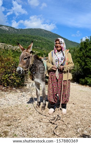 Kemer, Turkey - October 13: Danube Delta. Undefined Old Woman In National Dress With A Donkey. In The 1990s, Kemer Has Become One Of The Largest Tourist Centers Of Turkey, On October 13, 2012 In Kemer