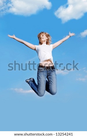 Jumping young woman at the clear blue sky background