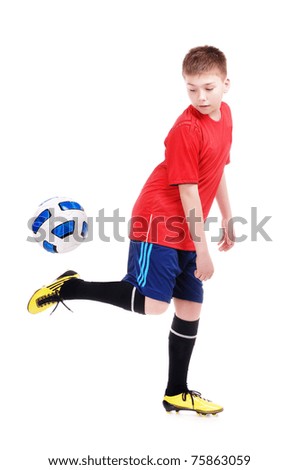Young football player playing with a ball on white background