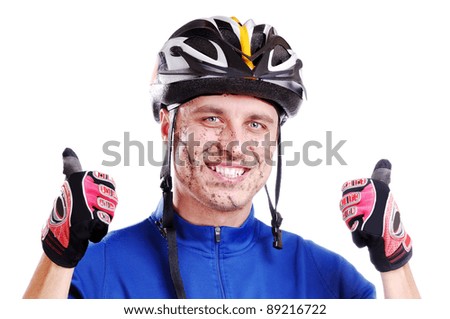 Cros-country cyclist with mud on his happy face