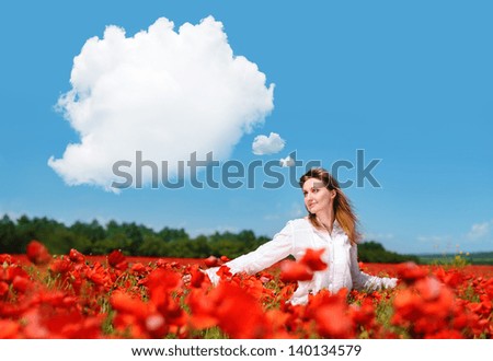 Young woman walking in a poppy field looking to the clouds thought bubble in the blue sky