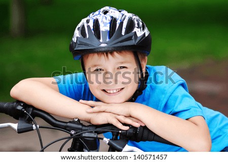 happy boy cyclist holding hands on his bicycle handlebar