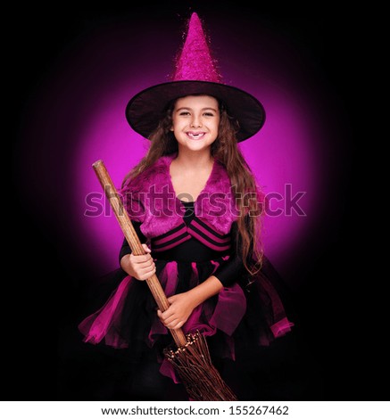 smiling halloween witch holding witch broom on dark background