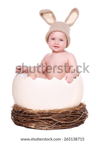 baby girl in a rabbit hat sitting in a giant egg