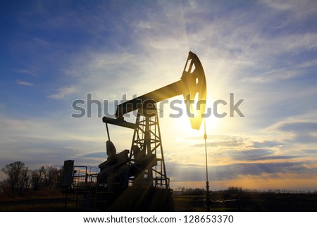 working oil pump at sunset with sunbeams working oil pump at sunset with sunbeams