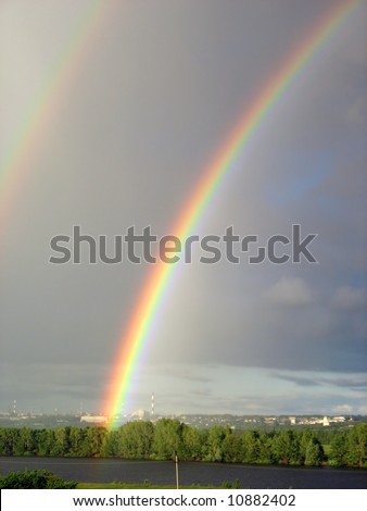 vertical landscape with rainbow over lake after storm