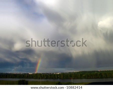 storm clouds landscape with rainbow over lake