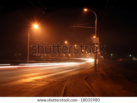 traffic on night road with street lamps in fog