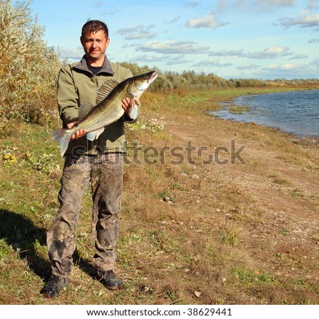 fishing man on coast with big zander fish