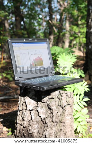 laptop on stump in forest - mobility concept