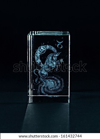 Laser engraving zodiac signs inside the glass on a black background.