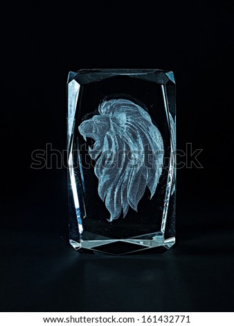 Laser engraving lion inside the glass on a black background.