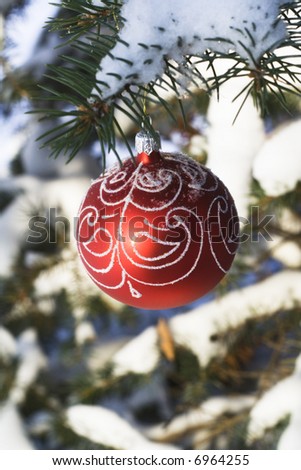 Christmas tree decoration handing on fir tree covered with snow