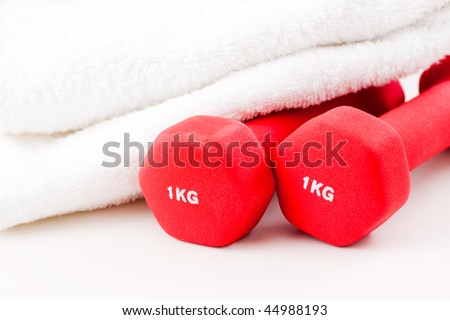Two red dumbbells and white sport towel