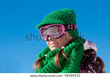 Young sporty girl wearing ski mask and hat. Winter vacation in Alps