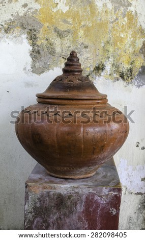 Thailand traditional clay jar used for water drink with grunge background.