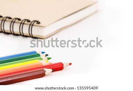 Coloring pencil  and notebook on white background