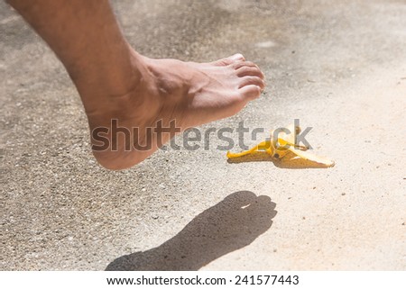 Foot before slipping banana peel on cement floor