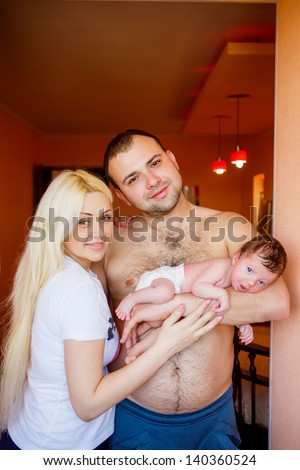 Happy family: mother, father and 10 day old newborn baby