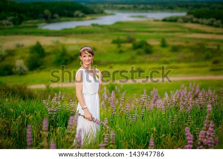 portrait of a beautiful girl in the Greek manner in a field of flowers