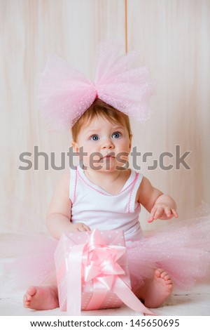 beautiful little girl with a big bow on her head with a gift