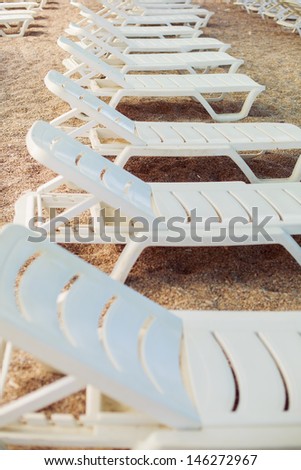 Rows of empty traditional deck chairs on beach