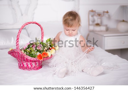 girl in a beautiful dress on a bed with a basket of flowers