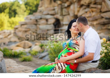 beautiful pregnant woman with her husband in the park
