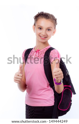 Young school girl ready for school. Little pupil is going to school. Happy young schoolgirl with satchel white background. Portrait of smiling, little girl in school uniform with backpack.