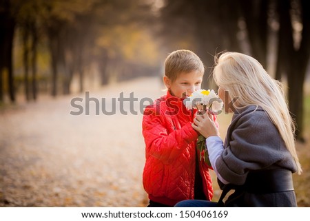 son gives a bouquet of white roses to my mother. autumn. autumn park. tenderness.