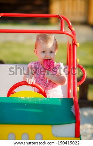 beautiful girl on the playground with a lollipop. close-up
