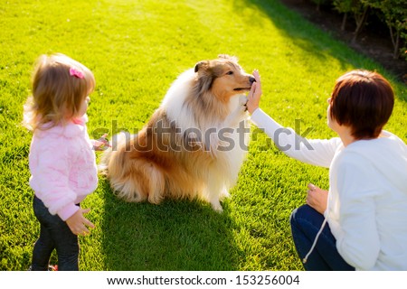 Happy mother and daughter on a walk with the dog Collie