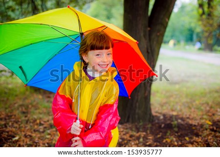 happy child in the rain with a bright umbrella