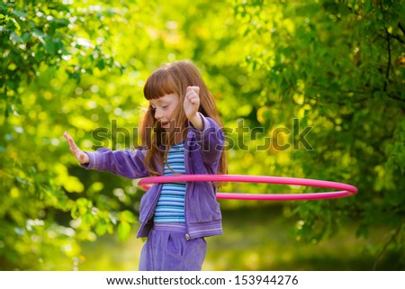 happy girl with red hair with a hula-hoops