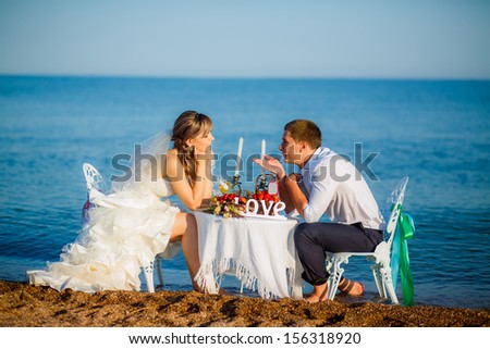 happy couple at the table by the sea. look at each other