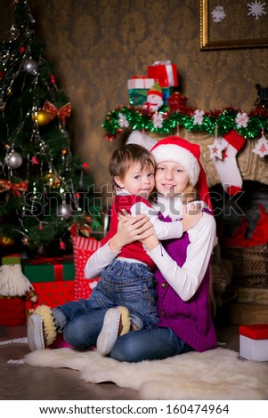 Brother and sister hugging near a Christmas tree