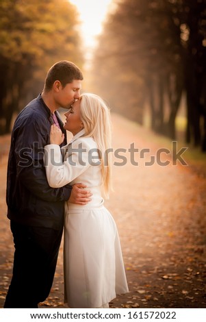 A love story. A man and a woman on autumn road. Love and relationships. Autumn sunset.