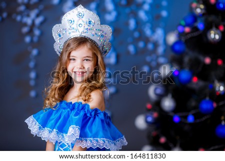 little girl in suit Snow Maiden near the Christmas tree