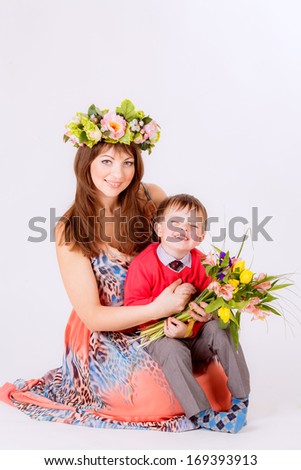 son hugging his mother and gives her flowers,  tulips. Spring, March 8, International Women\'s Day, smile