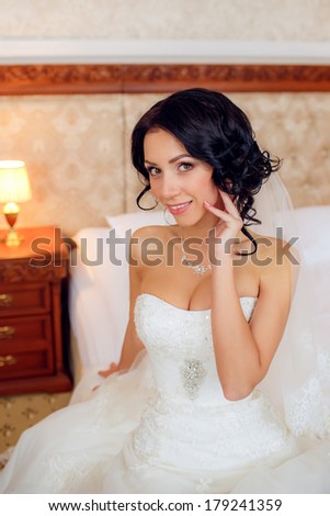 portrait of a happy bride in a wedding dress in the room