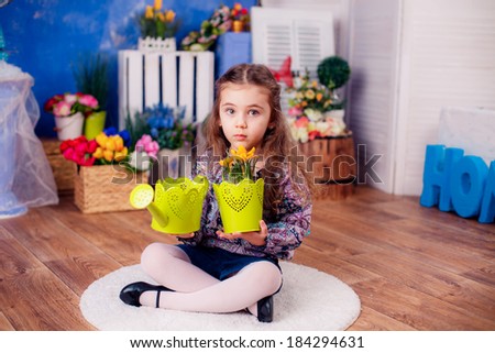 happy little girl. watering the flowers in the pot. Mother\'s Day, March 8, International Women\'s Day