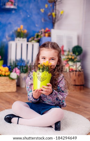 happy little girl smelling flowers. March 8, International Women\'s Day