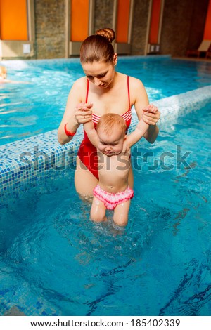 mother with a child is engaged in the pool. prevention of diseases of the musculoskeletal system