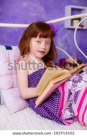 beautiful red-haired girl reading a book room