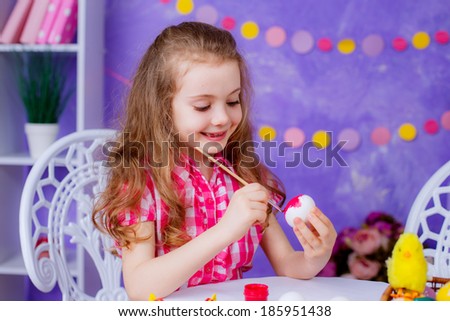 beautiful little girl paints eggs for Easter. Easter. holidays, emotions, happy
